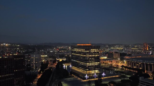 Department of Water and Power building in Los Angeles at twilight with illuminated cityscape showing Bunker Hill and Ahmanson Theatre in background