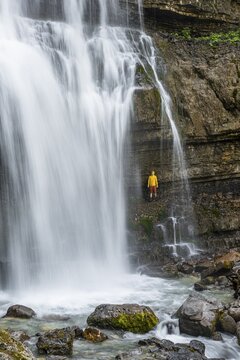 Adventure, Little hiker under large Cascata di Mezzo waterfall, long exposure, Vallesinella, Brenta, Trentino, Italy