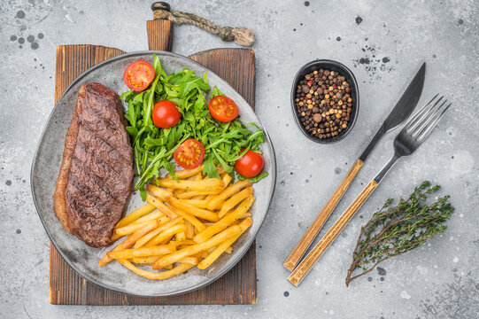 Juicy grilled beef culotte steak with potatoes and arugula salad, sirloin cap cut served for lunch or dinner