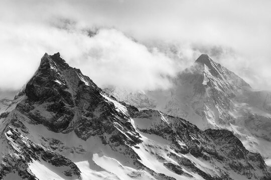 Fog envelops the snowy summit of the mountain Le Besso, Val d'Anniviers, Valais Alps, Canton Valais, Switzerland