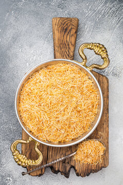 Raw kataifi pastry strands for kunafa and Middle Eastern desserts. Thin shredded phyllo texture on concrete background