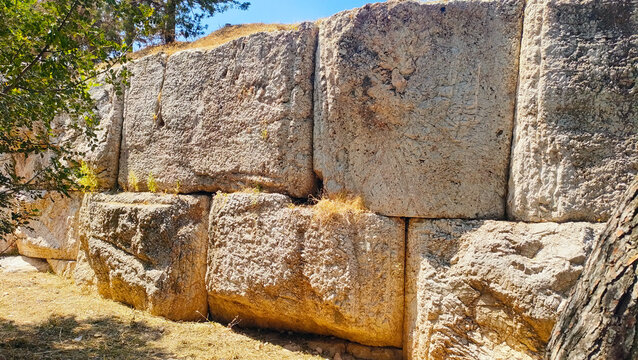 Ancient polygonal masonry wall at the Hill of the Nymphs, Athens, Greece, with megalithic stone blocks fitted without mortar, resembling the massive stone walls with distinct beveled edges in Baalbek