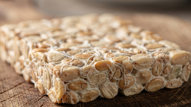 Raw Traditional Indonesian Tempeh Cake on Rustic Wooden Texture Close up
