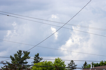 Fototapeta premium high voltage power lines with a cloudy sky and trees