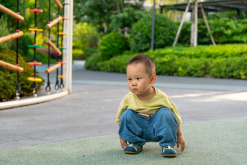 Fototapeta premium Toddler boy watching playground activity outdoors