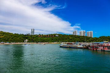 Fototapeta premium The Pattaya city sign at Khao Phra Tamnak, as seen from Laem Bali Hai Pier, is an iconic landmark that tourists from around the world must check in at. Chonburi, Thailand.