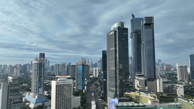 Menteng, Indonesia - 01 April 2025: Aerial view of the Jakarta skyline featuring modern skyscrapers like the BCA Tower under a cloudy sky in the central business district.