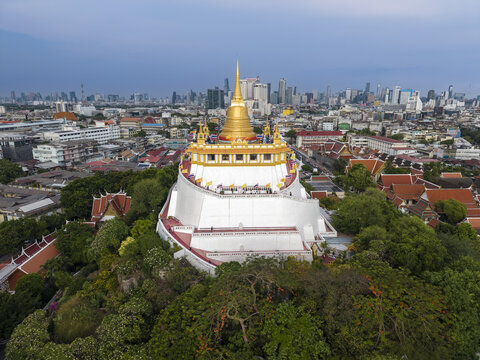 Bangkok, Thailand - 26 April 2026: Aerial view of Wat Saket Ratchawora Mahawihan, the Golden Mount, with its golden chedi rising above the city skyline and lush greenery.