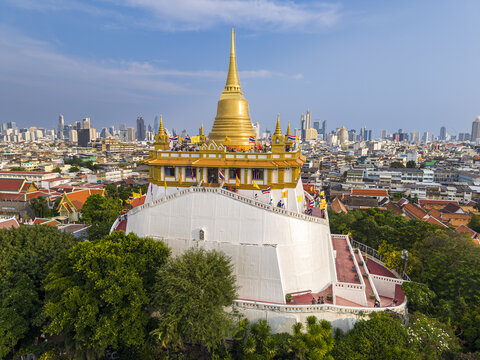 Bangkok, Thailand - 26 April 2026: Aerial view of Wat Saket Ratchawora Mahawihan, the Golden Mount, with its iconic golden chedi rising above the city skyline and lush greenery.