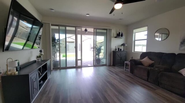 Bright modern living room with brown sectional sofa and glass doors