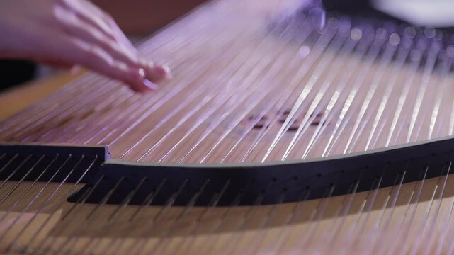 Musician hands playing ancient stringed gusli instrument