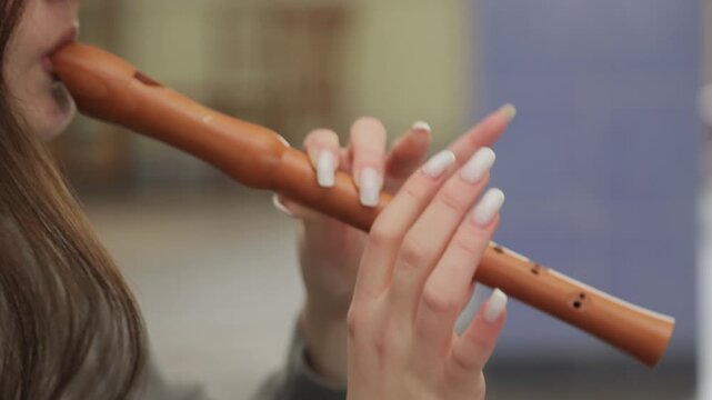 Young woman playing a traditional wooden flute