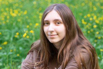 Fototapeta premium Young woman smiling at camera in summer park portrait