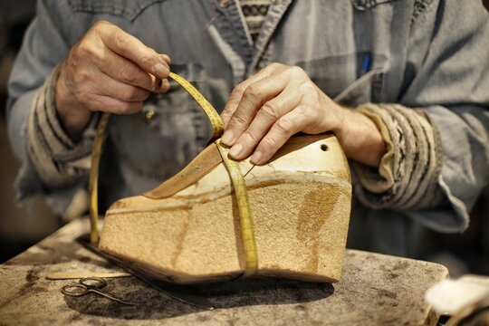 Cobbler hands measuring a cork wedge shoe