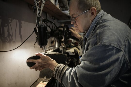 Senior craftsman mending a shoe in his workshop