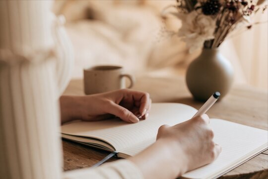 Woman writing her thoughts in a blank journal