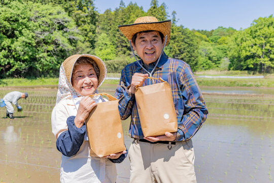収穫した農産物を手に笑顔を見せるシニア夫婦のポートレート