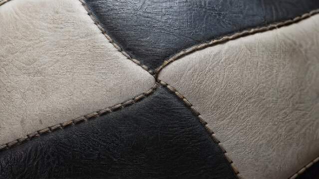 Close-up macro view of intricate stitching on a professional football showing textured leather surface and durable seam construction for sports industry and athletic gear marketing displays.