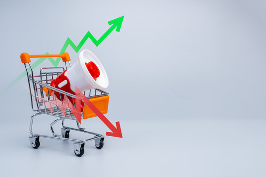 Shopping cart with megaphone and market trend arrows representing e-commerce performance, sales growth and market volatility. Business marketing concept with rising and falling financial indicators.