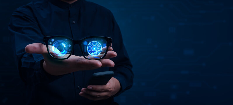 Person holding AI smart glasses with futuristic augmented reality interface and digital hologram display. Concept of wearable technology, artificial intelligence, smart vision and future innovation.