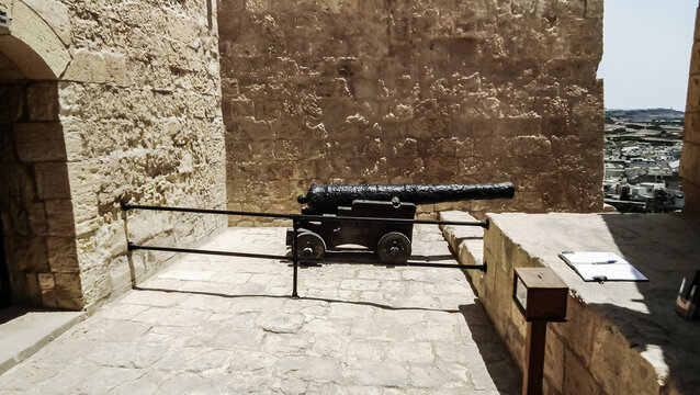 Old cast iron cannon stands on fortress wall of Citadella de Victoria Citadel in Rabat Victoria town on Gozo Island in Malta