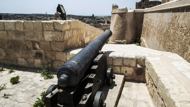 Old cast iron cannon stands on a fortress wall of Citadella de Victoria Citadel in Rabat Victoria town on Gozo Island in Malta