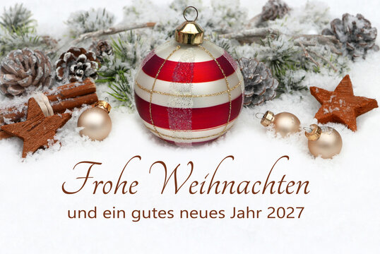 Weihnachtsgru&szlig;karte im Schnee mit Christbaumkugeln, Tannenzapfen, und beschneiten Tannenzweige. Im Vordergrund steht der Schriftzug &bdquo;Frohe Weihnachten und ein gutes neues Jahr 2027&ldquo;.
