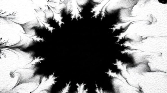 Large black ink splat with spray droplets on a white textured paper background.