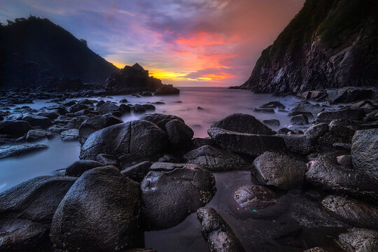 Dramatic Sunset at Payangan Beach with Rocky Coastline and Ocean Waves, Jember, East Java Indonesia