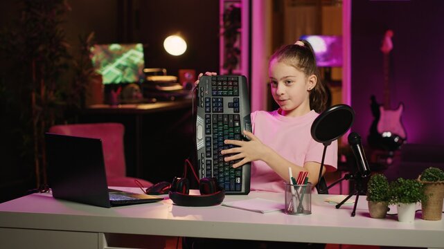 Children internet show host promoting keyboard, mouse and headphones received from sponsoring brand. Young kid star does influencer marketing, urging followers to purchase computer peripherals