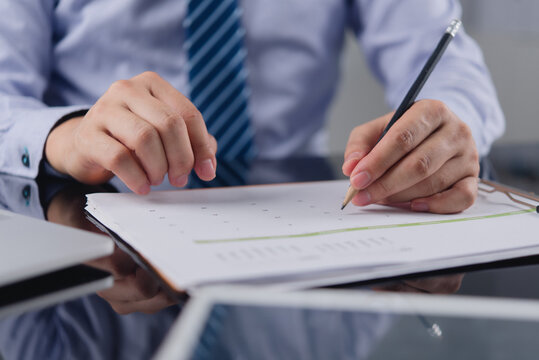 Businessman scheduling corporate agenda holding pencil writing on calendar planner organizing business appointment timeline managing time strategy at office workspace for commercial productivity
