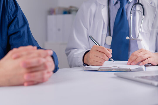 Doctor consulting patient writing medical prescription on clipboard at clinic desk reviewing disease diagnosis for healthcare pharmacy insurance advertising commercial campaign promotion
