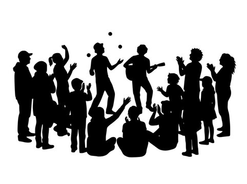 Silhouette of a crowd watching street performers juggler and guitarist