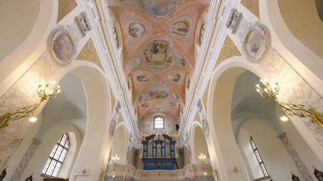 Vilnius, Lithuania &ndash; June 6, 2026: Cinematic slide inside the Church of the Assumption of the Blessed Virgin Mary featuring the historic pipe organ