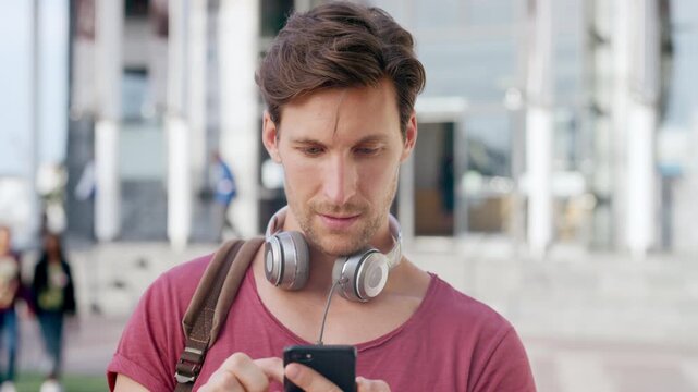 Man, student and phone with texting in city at campus with smile, check notification or online dating. Gen z person, happy and scroll with mobile app, contact and post on social media at university