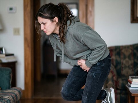 Young woman holding her groin in pain
