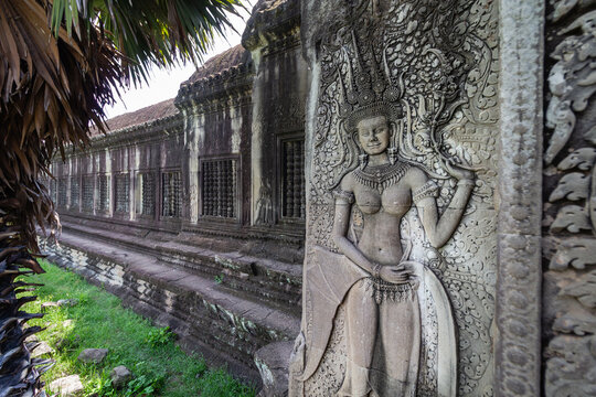Ancient Devata stone carving on the exterior wall of the historic Angkor Wat temple in Siem Reap Cambodia