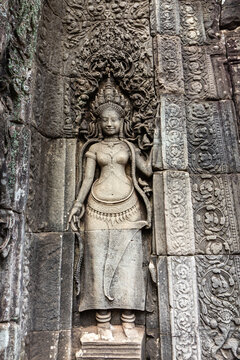 Intricate vertical Devata relief sculpture carved into the ancient stone walls at the Bayon temple in Cambodia