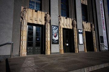 Fototapeta premium Art deco theatre entrance with sculpted figures and dramatic shadows in Katowice, Poland