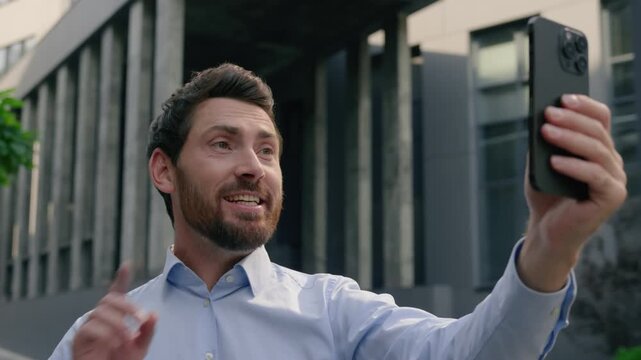 Happy Caucasian middle aged business man smiling waving hand video call mobile phone city male businessman using smartphone virtual conference app talk online web camera influencer cellphone outside