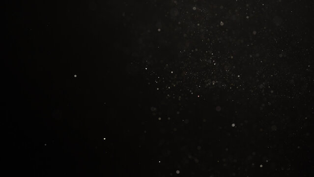 Slow motion real dust flow over dark background