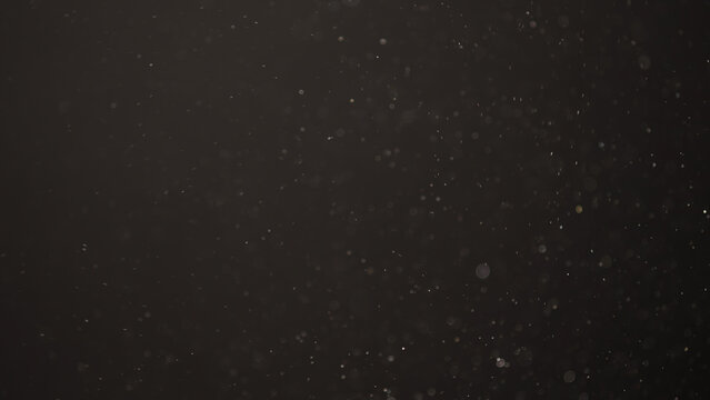 Slow motion real dust flow over dark background