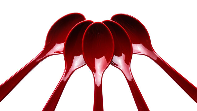 Isolated vibrant red plastic spoons arranged in a symmetrical fanned pattern, clean studio shot.