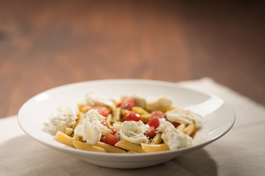 Penne pasta with mozzarella, pesto and fresh cherry tomatoes