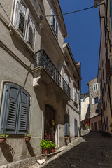 Fototapeta premium A walk through the narrow streets of Motovun in Croatia, high stone walls, lush Mediterranean vegetation, eat dishes with truffles, colorful walls,