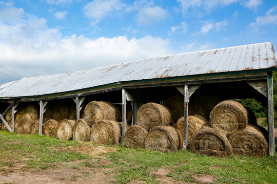 Hay bales stored beside a rural barn