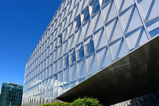Geneva, Switzerland, Europe :  05.2026 : Japan International Tobacco (JIT) - headquarters building with self-shading glass facade, at left - glass facade of WMO - World Meteorological Organization
