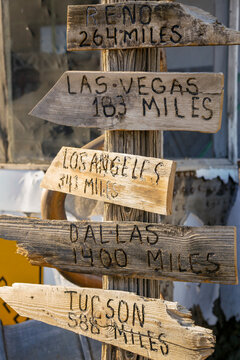 Rustic wooden mileage signs pointing to American cities
