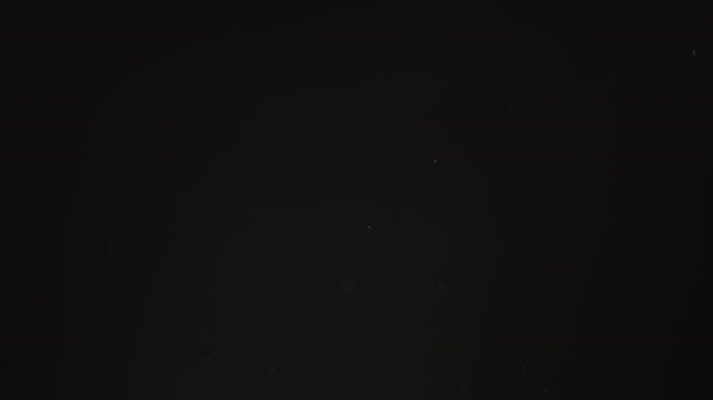 Slow motion real dust flow over dark background