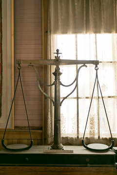 Antique scale silhouetted in a window